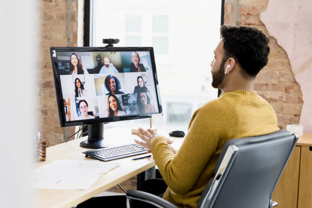 Image of a team leader doing a team review with his team virtually.