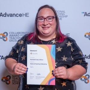 A photo of Rachelle Rawlinson. She is holding her national teaching fellowship award and smiling.