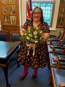A photo of Rachelle Rawlinson. She is holding a bouquet of flowers and smiling broadly.