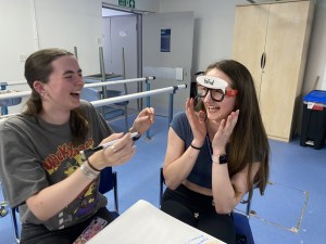 Using glasses to learn about anatomy. Two students learning and laughing.